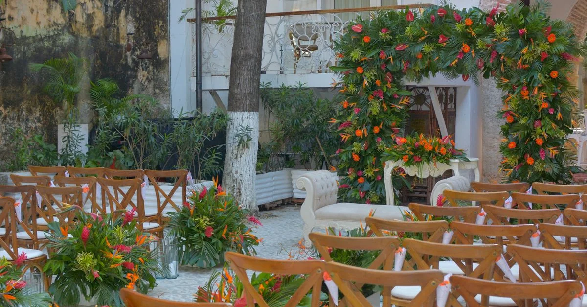 Une cérémonie de mariage en plein air magnifiquement décorée avec une arche florale et une élégante disposition des sièges.