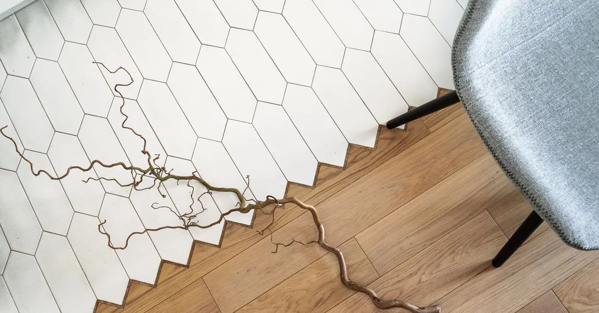 Vue de dessus d'un intérieur moderne avec un sol en bois et en carrelage présentant une branche décorative.
