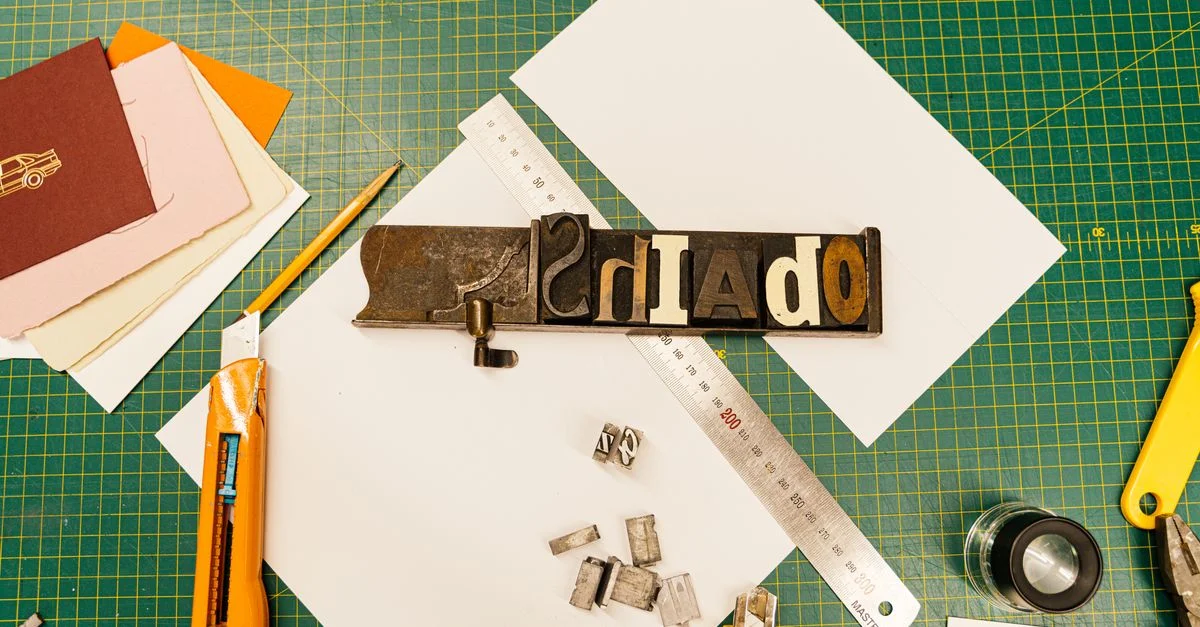 Une image en vue de dessus d'outils de typographie et de matériaux en papier pour des projets de impression créative.