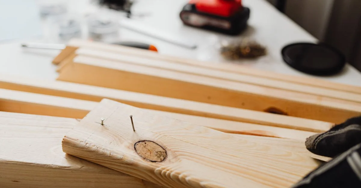 Gros plan sur le travail du bois, montrant une perceuse électrique et des planches en bois pour des projets de bricolage.