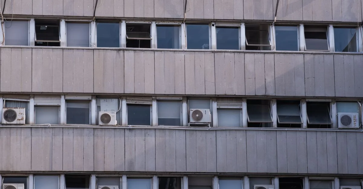 Vue extérieure de la façade d'un bâtiment en béton à Izmir, équipé de plusieurs climatiseurs.